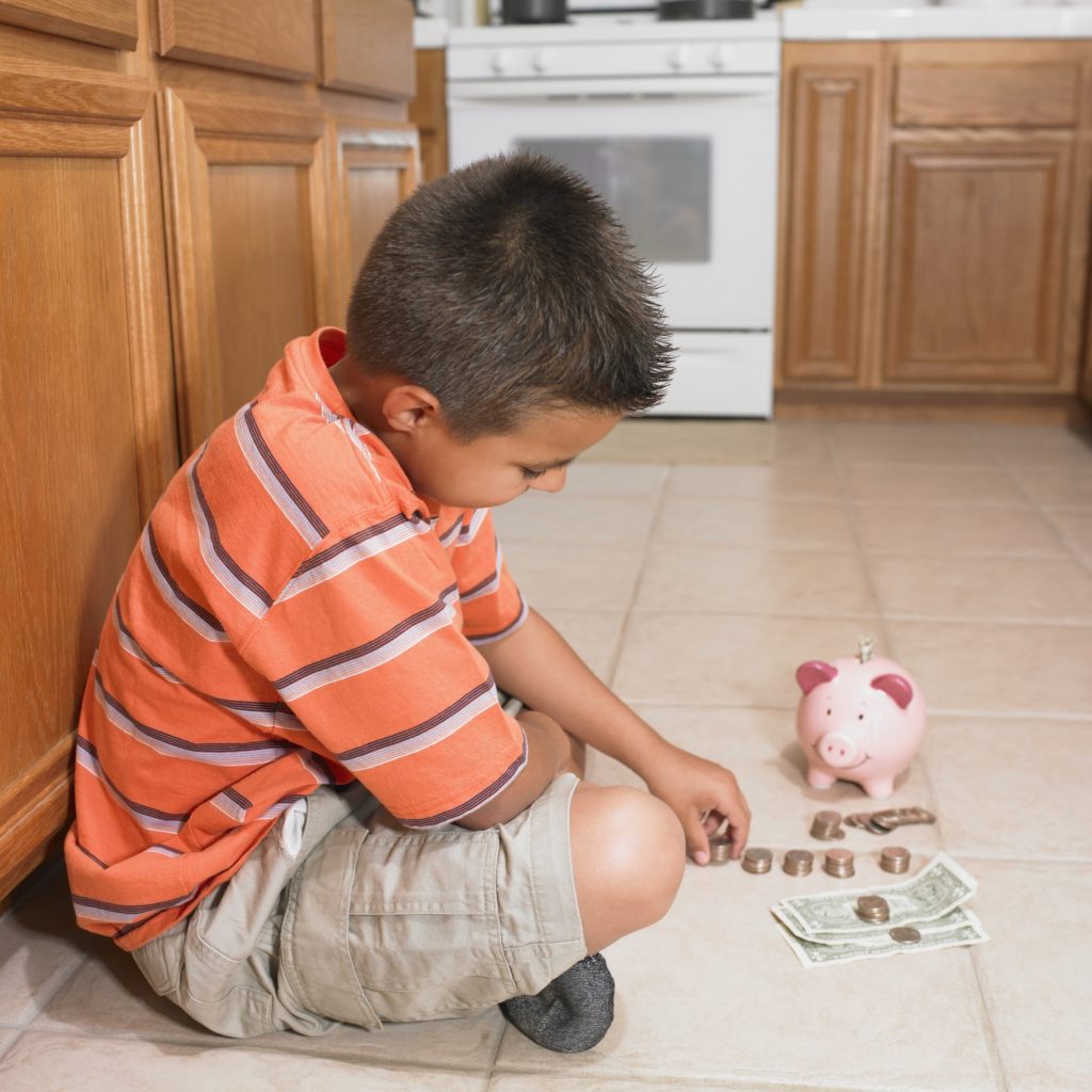 Boy counting money on floor