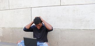 Frustrated young man using laptop