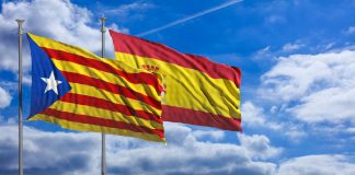 Catalonia and Spain flags waving on blue sky background. 3d illustration