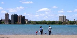 Family looks across lake at Detroit shyline