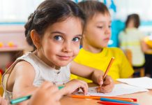 Group of cute little preschool kids drawing with colorful pencils
